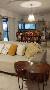 a couch with pillows and a table in a room at Sol & Río Refugio Serrano in Villa Las Rosas