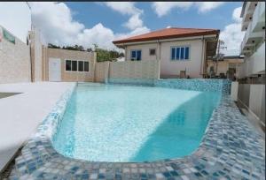 a swimming pool with blue water in front of a house at Cozy 1BR in Zef, Near Anjo World Wifi, Pool, Gym in Minglanilla