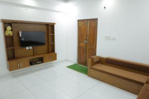 Una sala de estar con televisión y un sofá. en Souhrudam Apartments, en Hosdrug