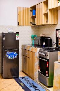 a kitchen with a stove and a refrigerator at AregeHomes in Nakuru