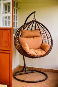a hanging chair with pillows in a room at AregeHomes in Nakuru