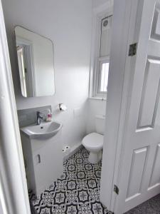 a white bathroom with a sink and a toilet at Dover Heights in Dover +12 photos
