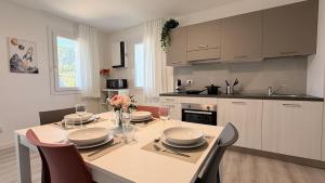 a kitchen with a table with chairs and a dining room at Residence Corte Astrale in Sesto al Reghena
