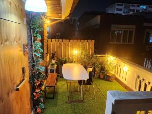 a balcony with a white table and some plants at 어반 팀버 수원 in Hagwanggyo-dong