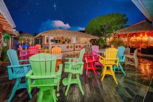 a group of colorful chairs and tables on a patio at Hotel Bambou in Les Trois-Îlets
