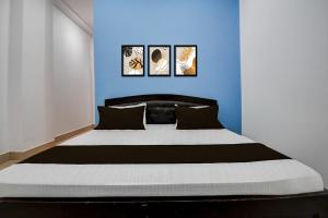 a bedroom with a large bed with a blue wall at Hotel O Rukmani Lawn in Bhauli