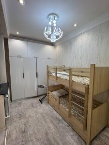 a room with two bunk beds and a chandelier at Almazar, Huvaydo apartament in Aktepa-Chigatay +13 photos