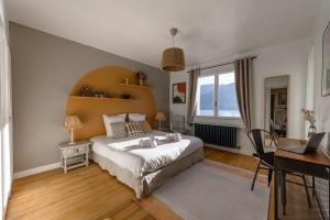 a bedroom with a large bed and a desk at Villa Alizé - Demeure familiale avec Piscine et Vue Panoramique in Sévrier +25 photos
