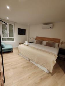 a bedroom with a large bed and a blue chair at TuApartamento Chapitela 16 by Clabao in Pamplona