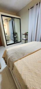 Los MameyesにあるGilmar Stay, A pasos de la Avenida Españaのベッドと大きな鏡のある寝室