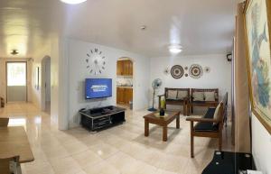 a living room with a tv on a wall at Seashells Home in Panglao Island