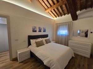 a bedroom with a large bed with white sheets at Residenze La Barchessa in Santo Stefano di Zimella +43 photos
