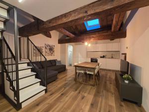 a kitchen and a living room with a table and a staircase at Residenze La Barchessa in Santo Stefano di Zimella