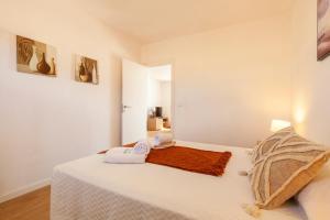 a bedroom with a white bed with towels on it at Quinta da Ponte in Odiáxere +53 photos
