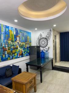 a living room with a table and a painting on the wall at FUNNY Hostel & cafe in Ho Chi Minh City