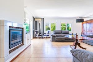 a living room with a couch and a fireplace at Villa Mario para 8 con piscina privada AA y Wi-Fi. in Vinaròs