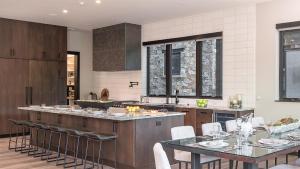 a kitchen with tables and chairs and a counter at Triple 3 Lodge in Steamboat Springs