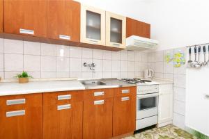 a small kitchen with wooden cabinets and a sink at Apartment Nela in Brna