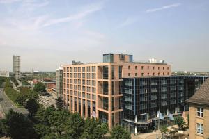 a tall building in a city with trees at NH Dortmund in Dortmund
