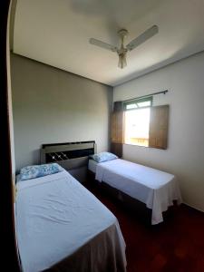 a bedroom with two beds and a ceiling fan at Casa Temporada Lençóis in Lençóis