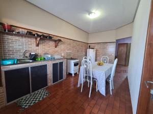a kitchen with a table and chairs and a refrigerator at Casa Temporada Lençóis in Lençóis +10 photos