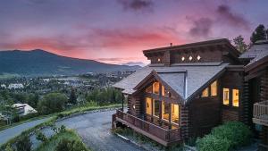 a log home with a sunset in the background at Watchtower Chalet in Steamboat Springs