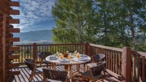a table and chairs on a deck with a view at Watchtower Chalet in Steamboat Springs