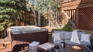 a hot tub on a patio with a table and chairs at Watchtower Chalet in Steamboat Springs