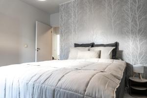 a bedroom with a large bed with a white wall at Downtown Rovaniemi, Perfect Location in Rovaniemi