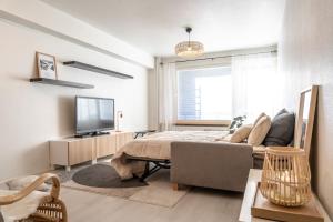a living room with a bed and a television at Downtown Rovaniemi, Perfect Location in Rovaniemi