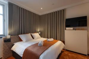a hotel room with a bed and a flat screen tv at Toope Guesthouse in Bruges +5 photos
