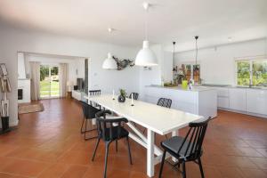 eine Küche und ein Esszimmer mit einem weißen Tisch und Stühlen in der Unterkunft Villa Atlantico in Poço Partido