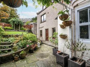 un jardín frente a una casa con macetas en Rowan Tree House, en Brechin