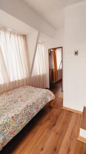 Un dormitorio con una cama con un edredón floral. en Alojamientos Marina Centro, en Viña del Mar 4 fotos más