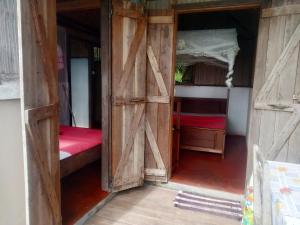 a room with two beds and a barn door at Le pied dans l'eau in Aniribe +20 photos
