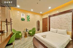 a hotel room with a bed and green chairs at S79 Hotel T68 Go Vap in Ho Chi Minh City