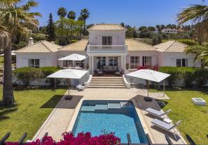 ein Haus mit einem Pool und zwei Sonnenschirmen in der Unterkunft Villa Atlantico in Poço Partido