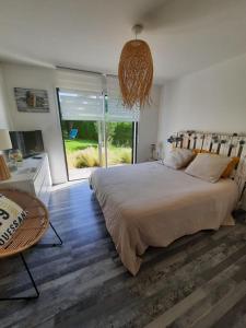 a bedroom with a large bed and a large window at Cap Coz Cottage 4* a 500 m de la plage de sable fin in Fouesnant