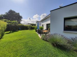 a garden with a table and chairs and a house at Cap Coz Cottage 4* a 500 m de la plage de sable fin in Fouesnant