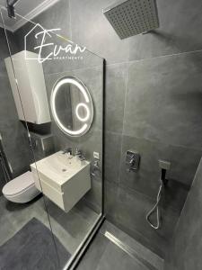 a bathroom with a sink and a mirror at Modern City View Apartment by Evan Apartments in Şelimbăr +11 photos
