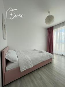 a bedroom with a bed in a white room at Modern City View Apartment by Evan Apartments in Şelimbăr