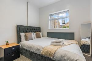 une chambre avec un grand lit et une fenêtre dans l'établissement Contractor Ready with parking in S10, sleeps 6, à Walkley 27 autres photos