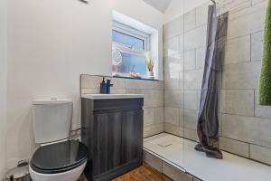 une salle de bain avec toilettes, lavabo et fenêtre dans l'établissement Contractor Ready with parking in S10, sleeps 6, à Walkley