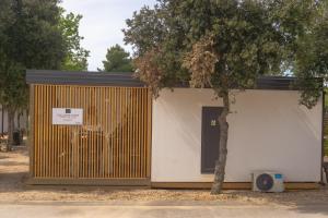 a building with a tree in front of it at Mobile Home Saky, Biograd na Moru in Biograd na Moru