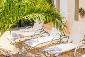 UtergaにあるAcogedora casa rural a 10 minutos de Pamplonaの植物の前の砂の上に置かれた3つの白い椅子