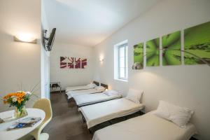 a row of beds in a room with a table at Gîte d'Etape des Capucins in Le Puy-en-Velay