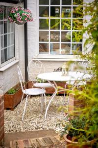 a white table and chairs sitting on a patio at Quaint 200 year old cosy characterful cottage in Swanland