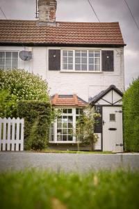 a white house with a gate and a white fence at Quaint 200 year old cosy characterful cottage in Swanland
