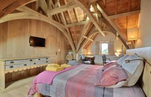 a bedroom with a large bed in a room with wooden ceilings at Propriété De Campagne Typique in Brasparts