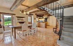 a kitchen and dining room with a staircase and a table and chairs at Propriété De Campagne Typique in Brasparts